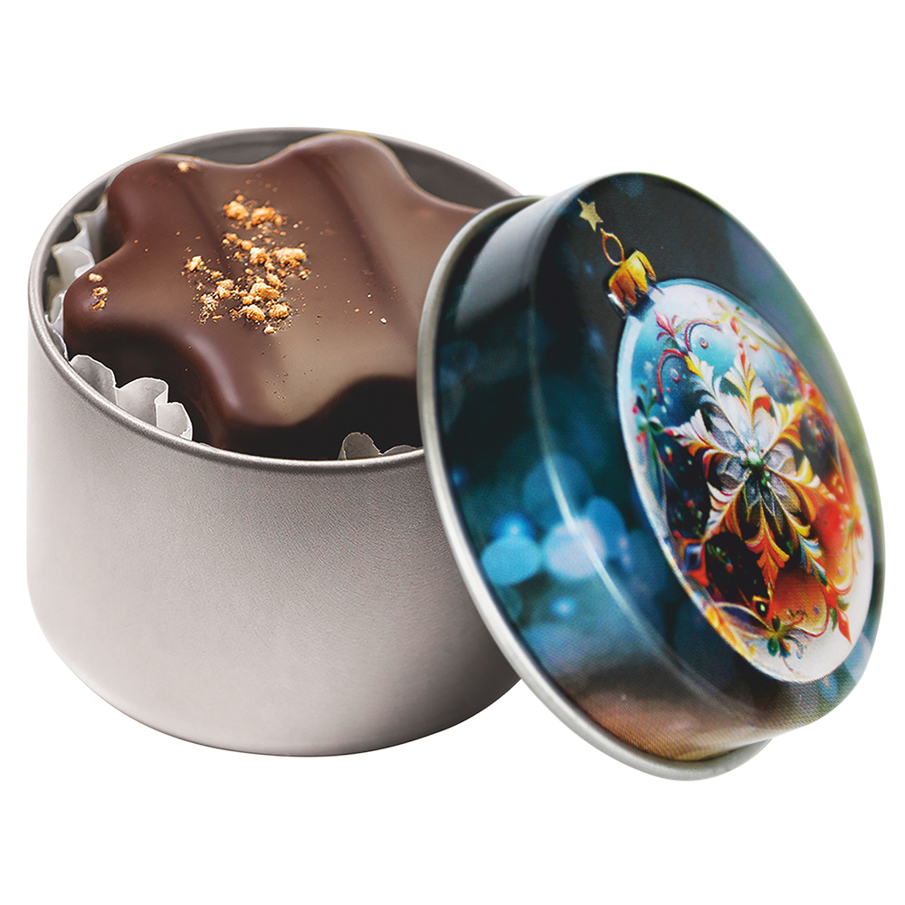 Geöffnete Weihnachtsdose mit buntem Kugel-Design und einer dunklen Schokoladenpraline in Sternform