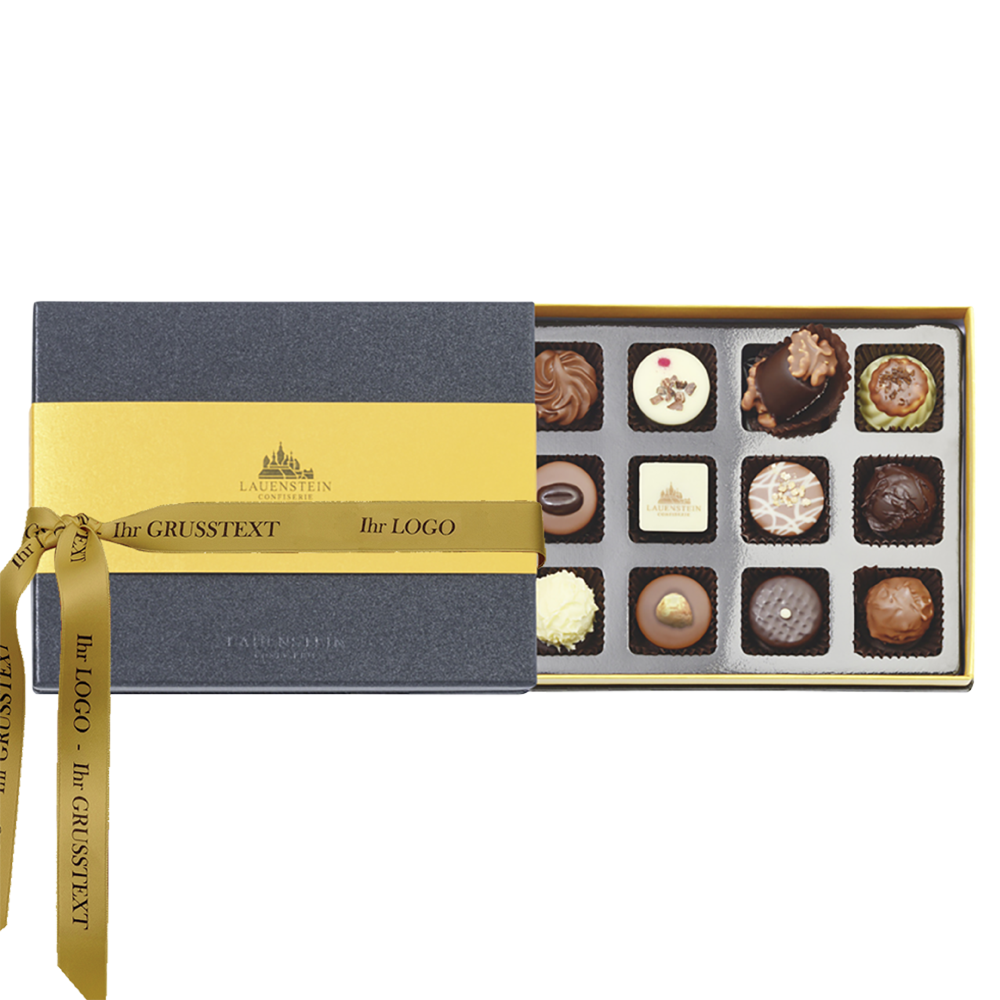 Geöffnete schiefergraue Pralinenpackung mit zwölf Pralinen; personalisiertes Schleifenband mit Grußtext und Logo am Deckel befestigt