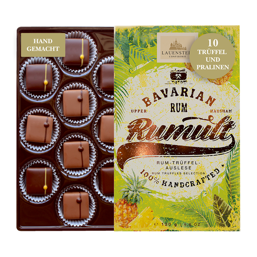 Geöffnete Lauenstein Schachtel Rumult mit zehn Rum-Trüffeln neben einer Verpackung im tropischen Design