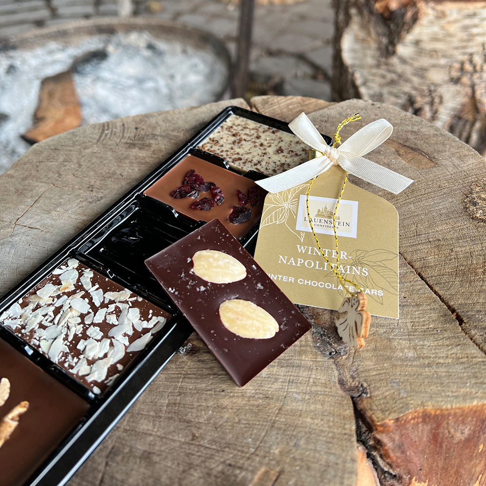 Geöffnete Packung Winter-Napolitains angerichtet auf einem Holzstamm