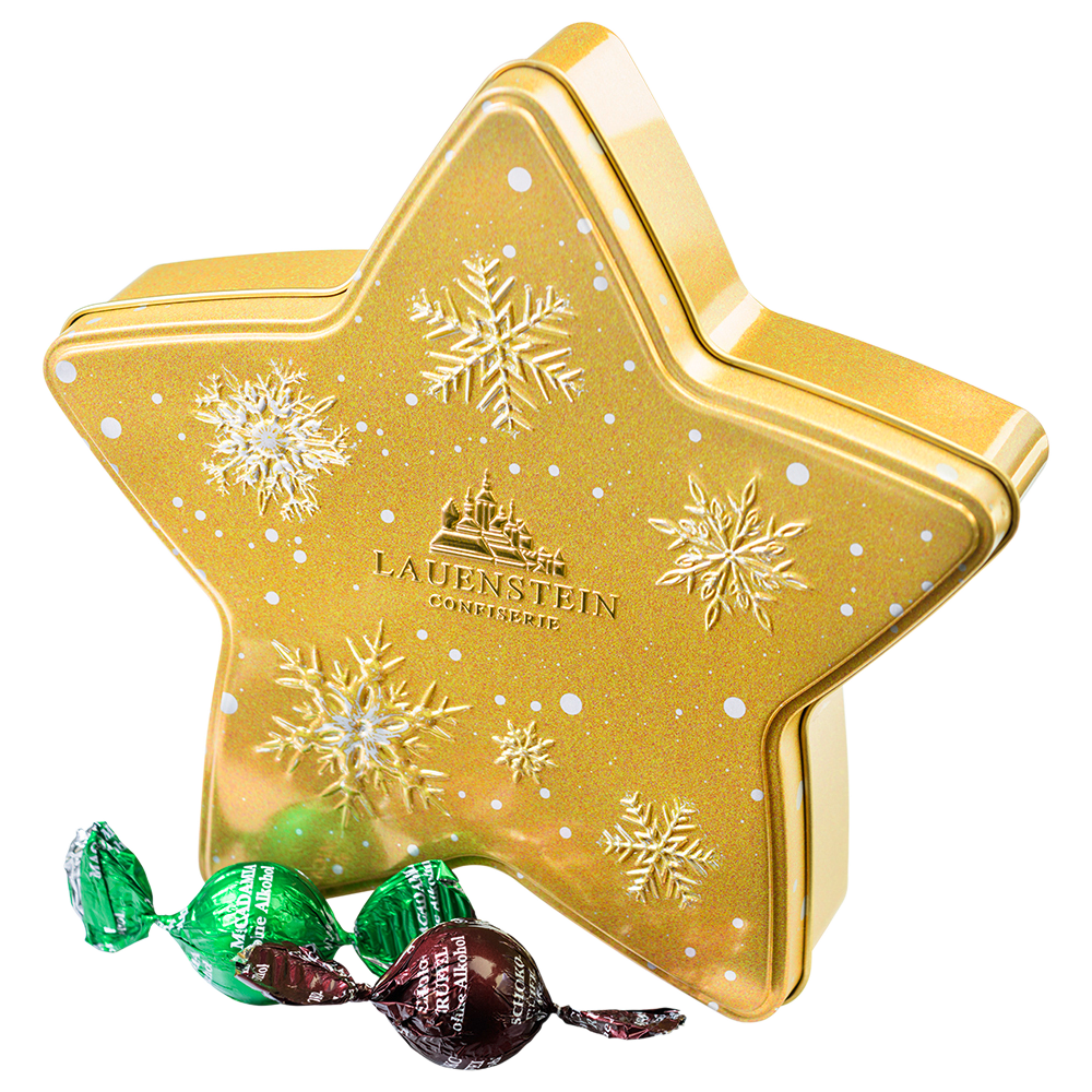Aufrecht stehende goldene Metalldose in Sternform mit weißen Schneeflocken-Motiven und Lauenstein-Logo neben zwei einzeln gewickelten Gourmetkugeln