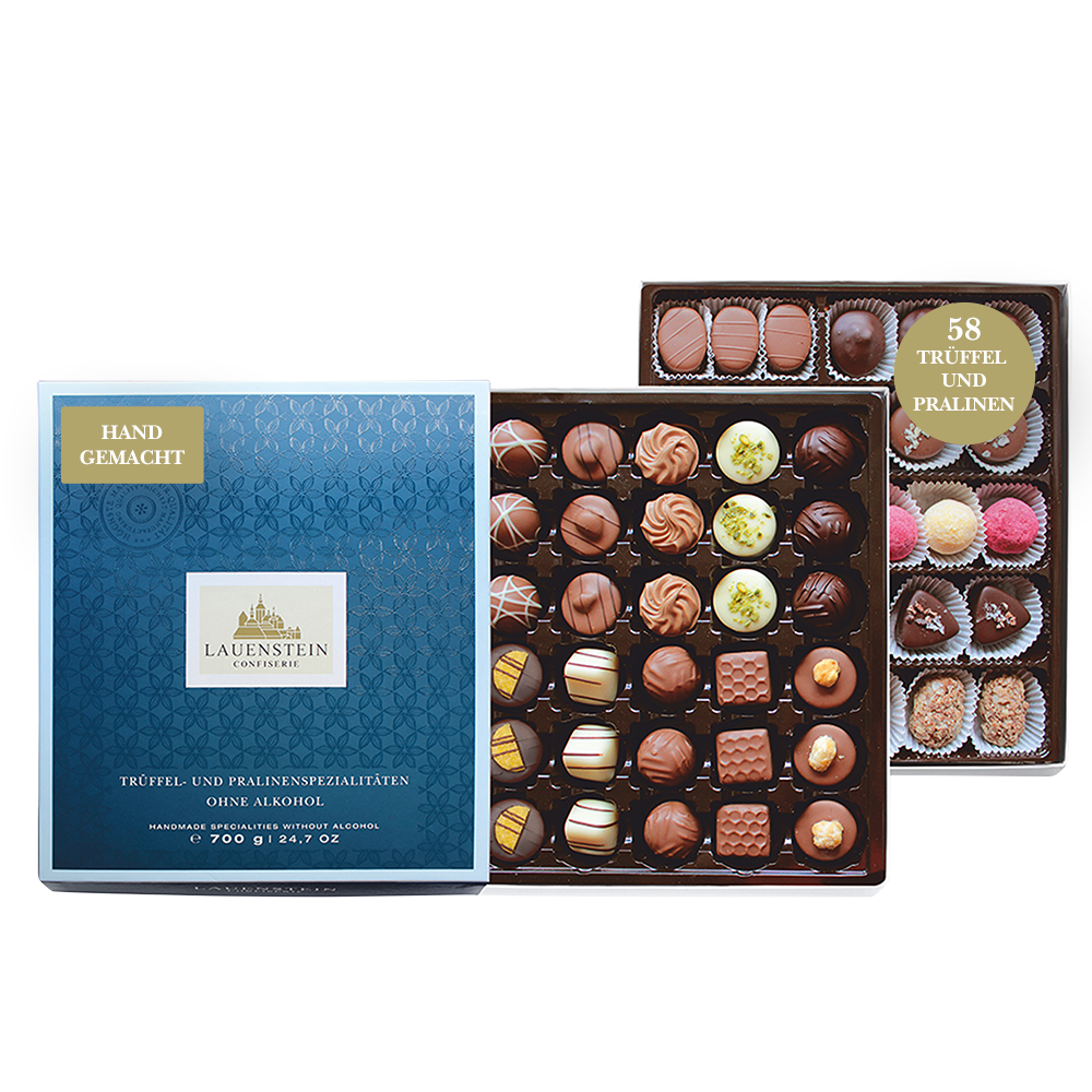 Zwei Pralinenlagen mit einer großen Auswahl an alkoholfreien Pralinen neben einer geschlossenen, dunkelblauen Lauenstein-Geschenkbox