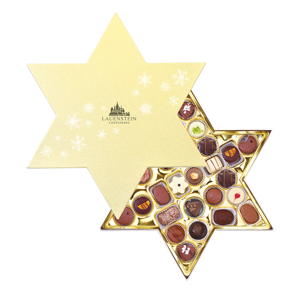 geöffnete Lauenstein Metalldose in Mondform mit buntem, winterlichem Tannenbaum-Design und 14 edlen Pralinen im goldenen Inlay