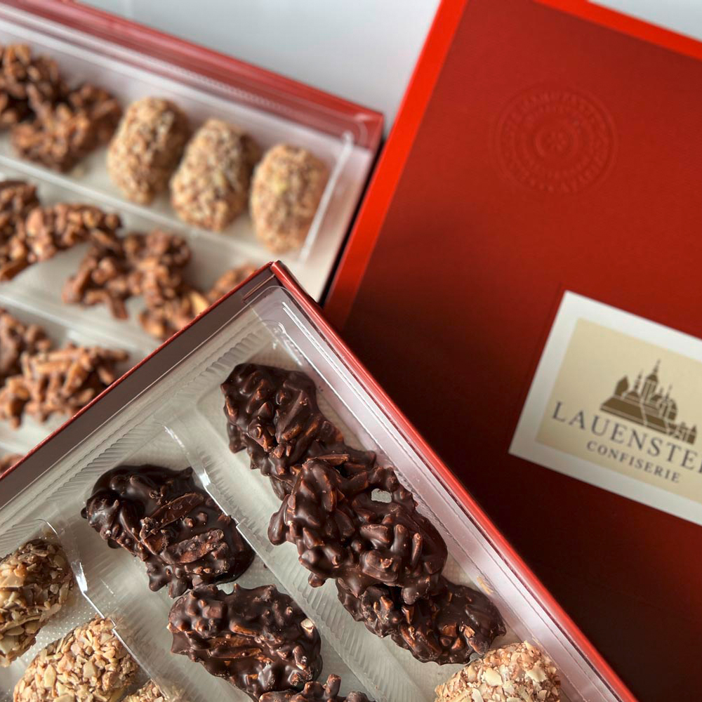 Nahaufnahme der beiden Mandelspezialitäten neben der Pralinenpackung