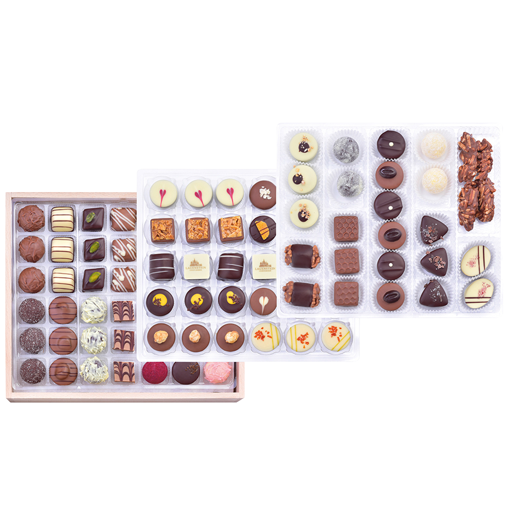 Drei prall gefüllte Lagen mit handgemachten Pralinen und Trüffeln aus der Draufsicht