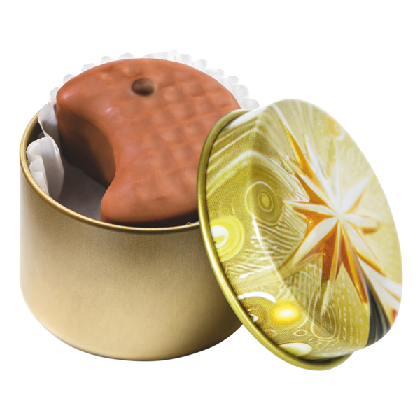 Geöffnete kleine goldene Metalldose mit Weihnachtsstern-Motiv und einer halbmondförmigen Vollmilch-Praline 