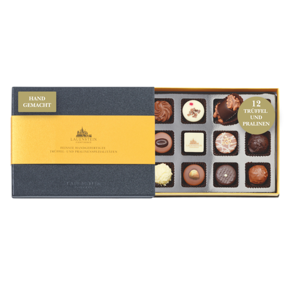Geöffnete schiefergraue Lauensteiner Pralinenschachtel mit goldener Banderole und zwölf verschiedenen, handgefertigten Pralinen
