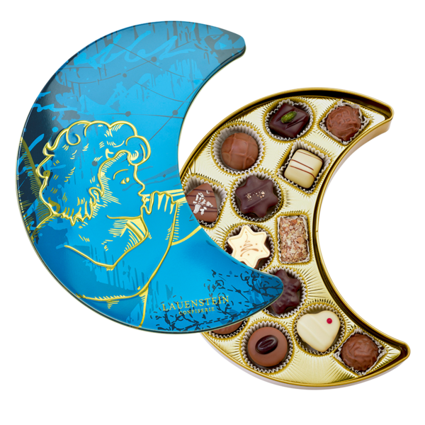 blaue Lauensteiner Geschenkdose aus Metall in Mond-Form mit Engel-Motiv, halb geöffnet und befüllt mit verschiedenen feinen Pralinen und Trüffeln
