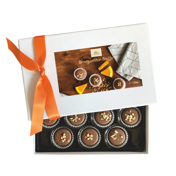 Lauenstein Orangenlikör-Trüffel in halb geöffneter, weißer Geschenkbox mit orangefarbener Schleife und Produktfoto auf dem Deckel