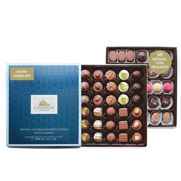 Zwei Pralinenlagen mit einer großen Auswahl an alkoholfreien Pralinen neben einer geschlossenen, dunkelblauen Lauenstein-Geschenkbox