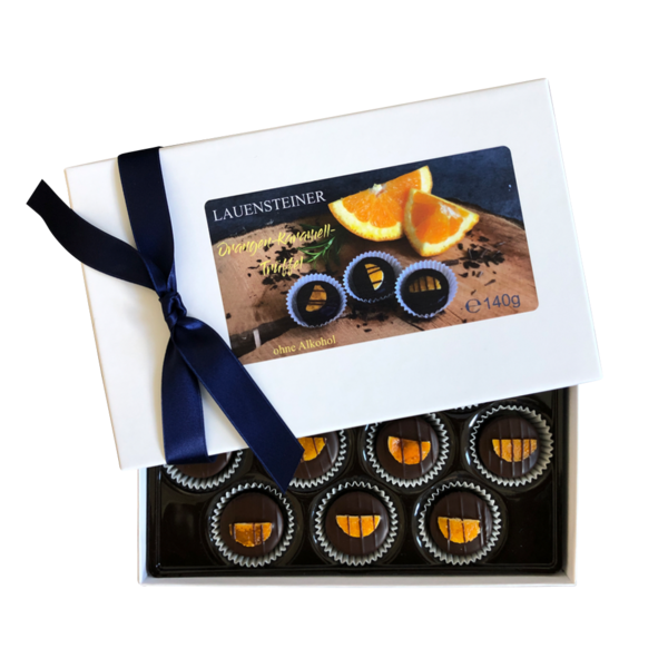 Lauensteiner Orangen-Karamell-Trüffel dekoriert mit Arancini-Stückchen in weißer Geschenkbox mit dunkelblauer Schleife