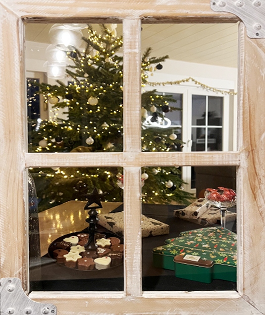 Stimmungsvoll verpackte Weihnachtsgeschenke vor leuchtendem Christbaum