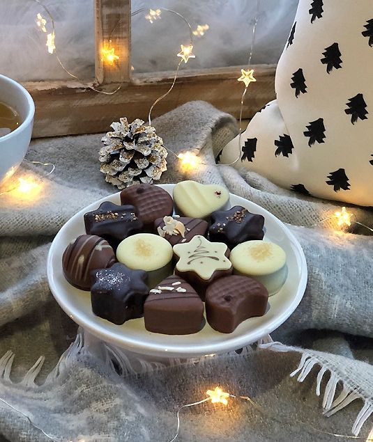 Weihnachtlich dekorierter Tisch mit Pralinen gedeckt