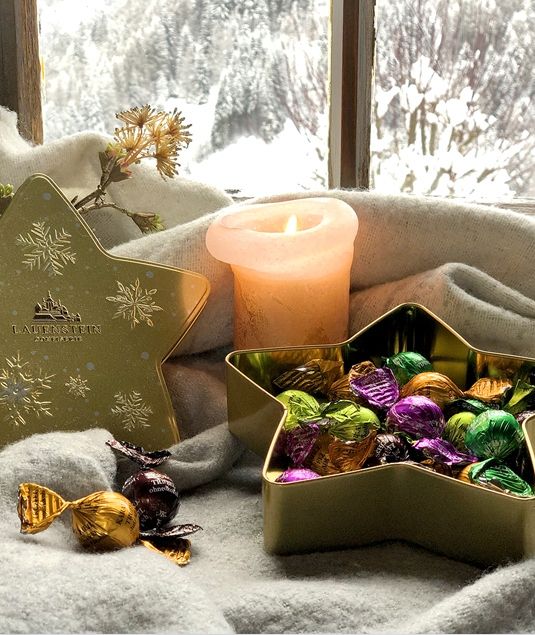 Stimmungsvoll verpackte Weihnachtsgeschenke vor leuchtendem Christbaum