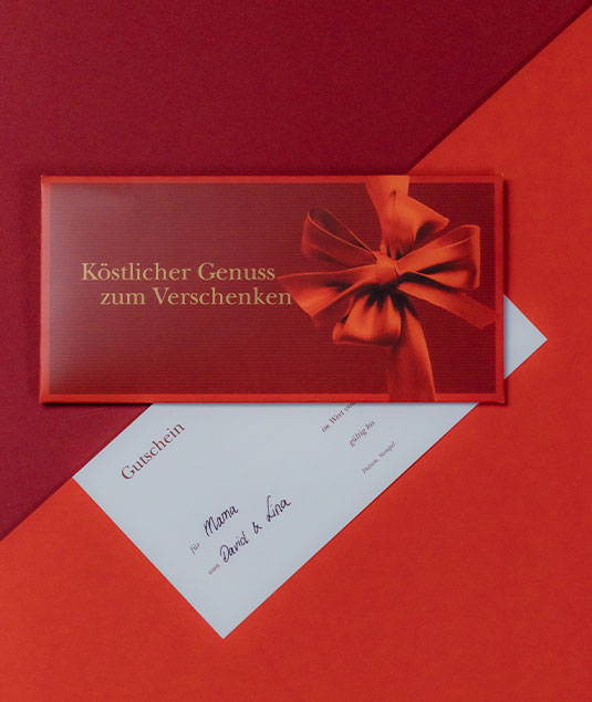 Roter Gutschein mit Schriftzug „Genuss zum Verschenken“
