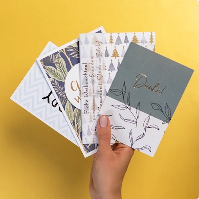 Verschiedene Grußkarten aufgefächert auf gelben Hintergrund