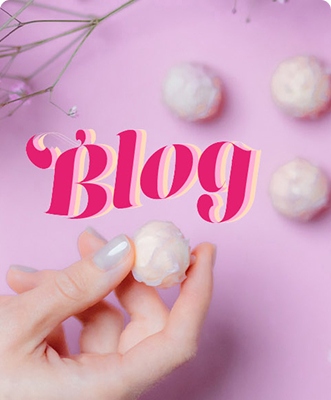 Bild mit pinken Hintergrund und Händen mit weißen Pralienen